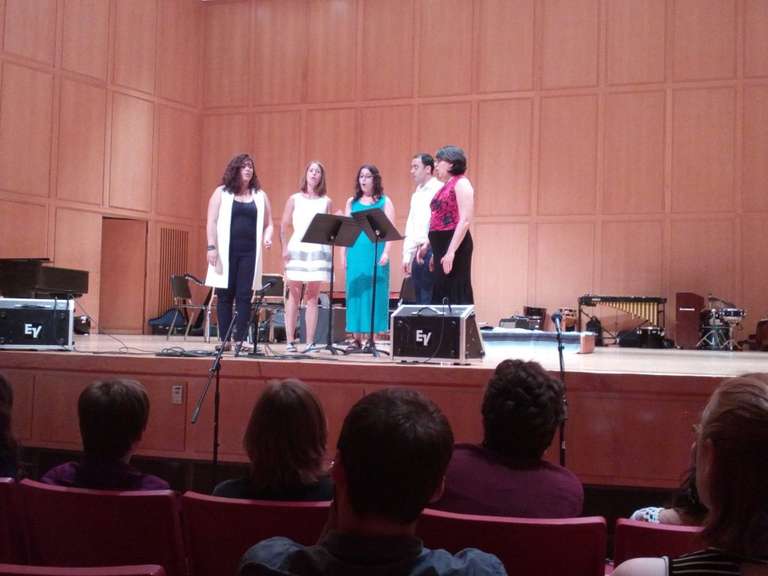 Jamie on stage with 4 other choristers, performing.